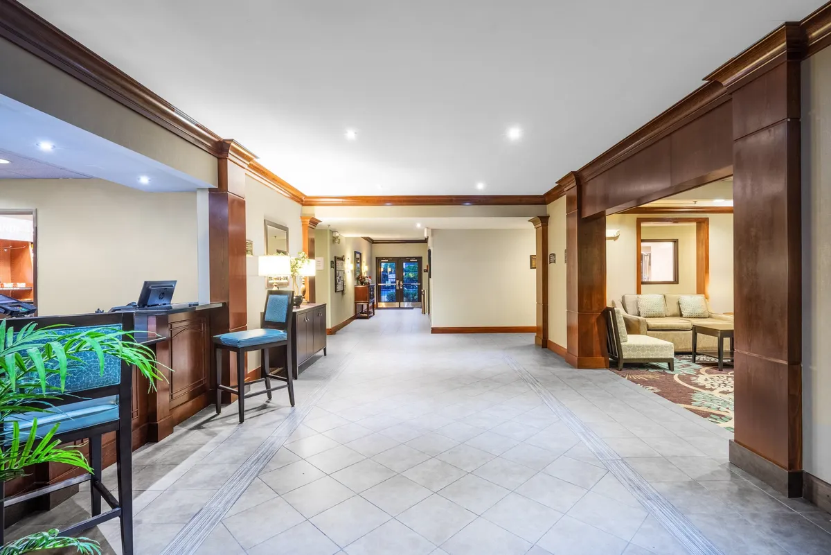 A welcoming interior with a reception desk, waiting area, and decorative plant, providing a glimpse into the inviting shared spaces available to guests.